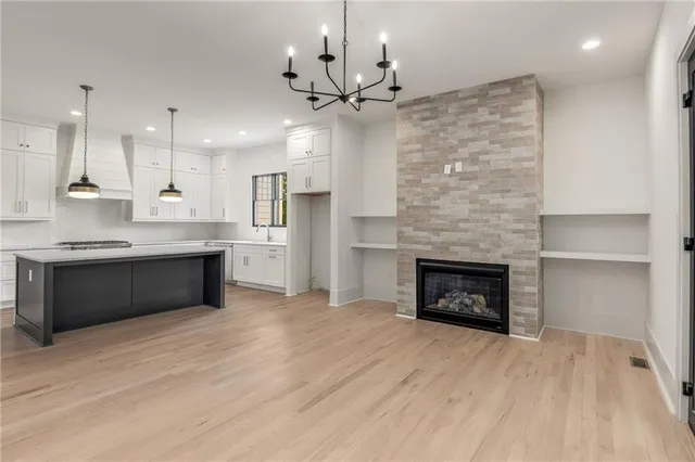 a kitchen with stainless steel appliances granite countertop a sink a stove and a wooden floors