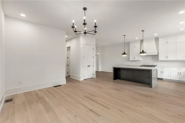 a kitchen with stainless steel appliances granite countertop a sink a stove and a wooden floors