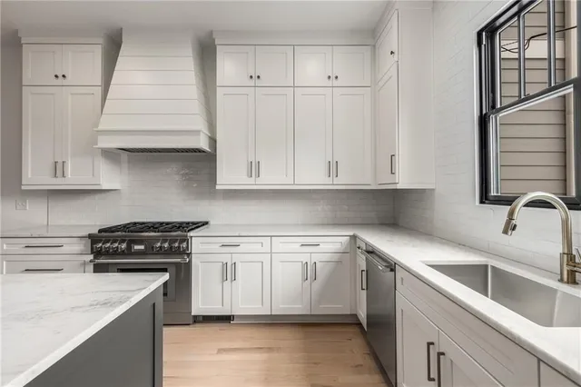 a kitchen that has a sink a window and a wooden floor