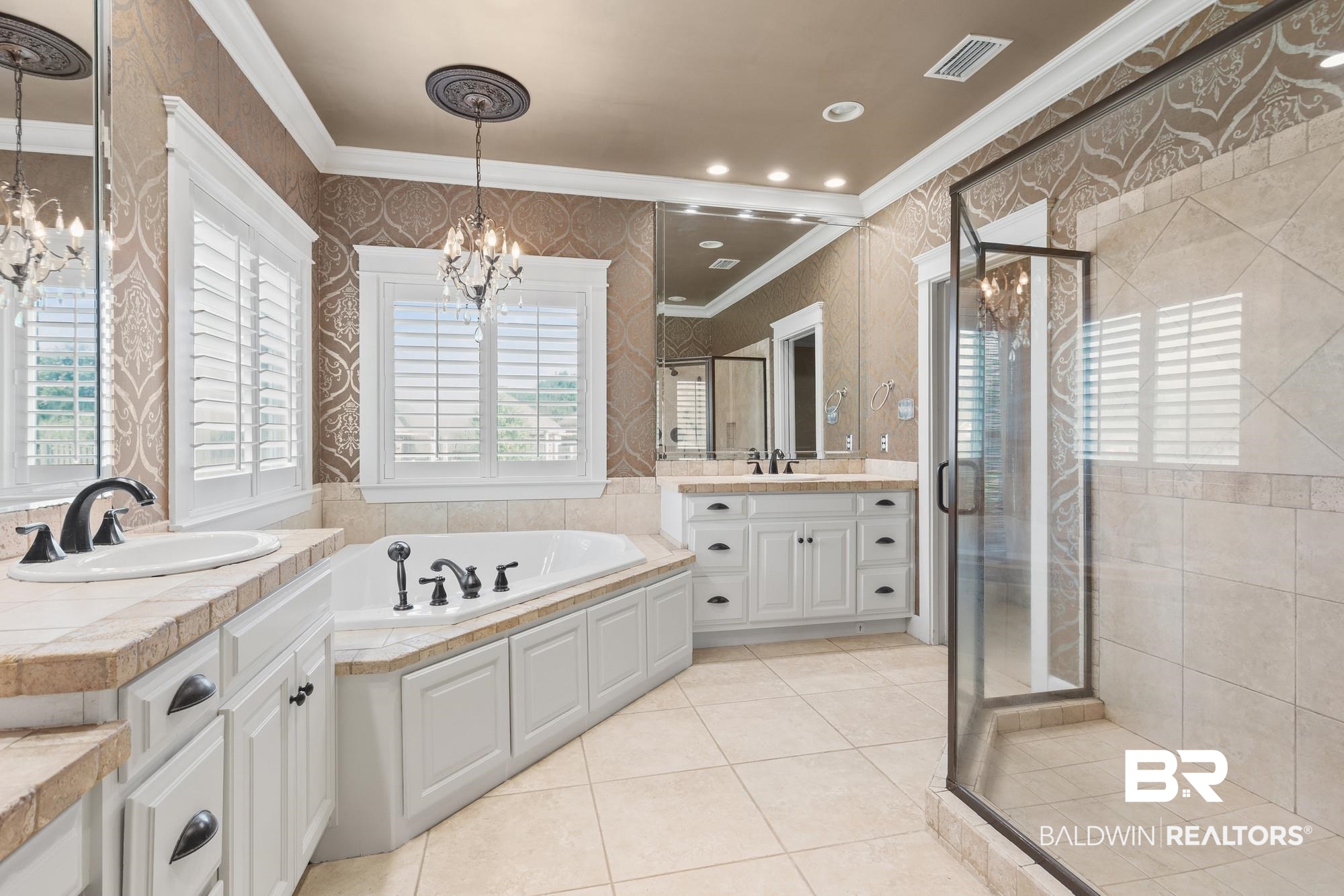 11261 Halcyon Loop Daphne, AL 36526 - Photo 18 of 41 Spacious bathroom featuring a built-in soaking tub, dual vanity with undermount sinks, separate glass-enclosed shower, and decorative wall coverings