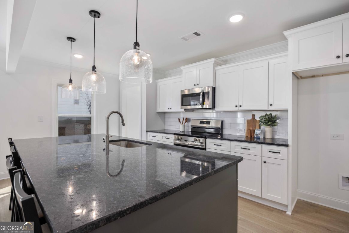 21 Rivers Edge Lane Franklin, GA 30217 - Photo 11 of 26 a kitchen with stainless steel appliances granite countertop a sink a stove and a wooden floors