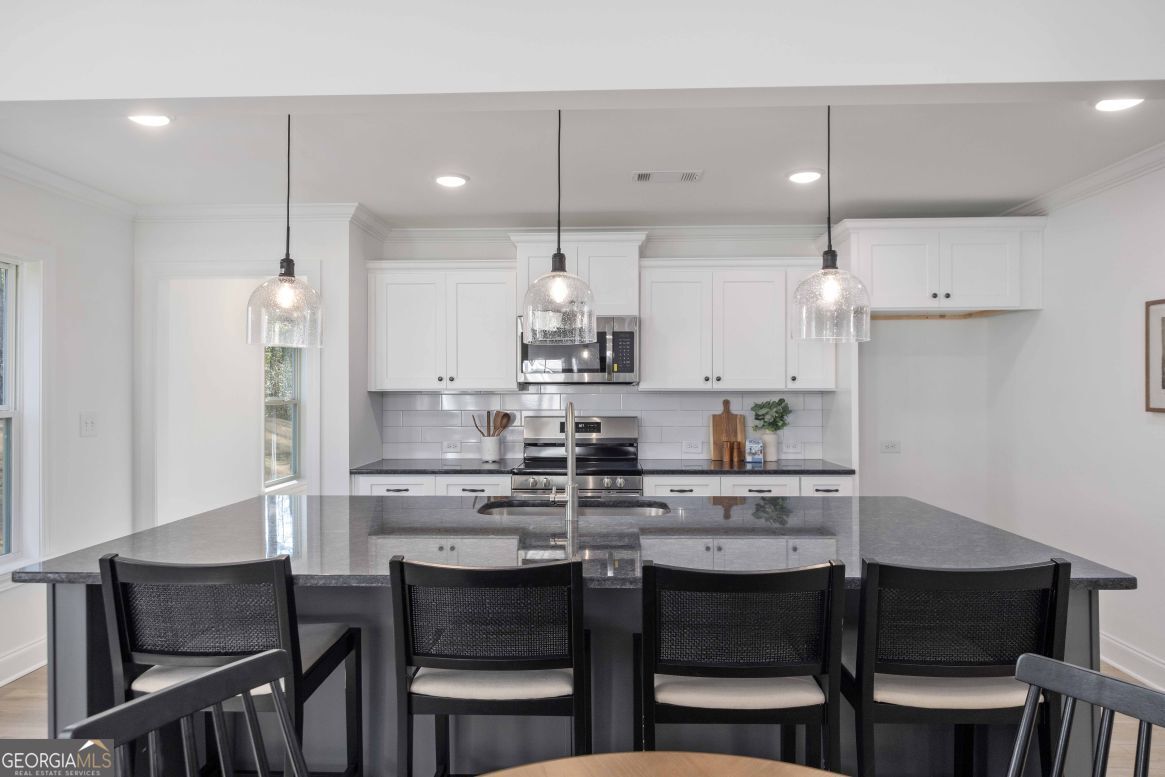 21 Rivers Edge Lane Franklin, GA 30217 - Photo 14 of 26 a kitchen with kitchen island a dining table chairs and white cabinets