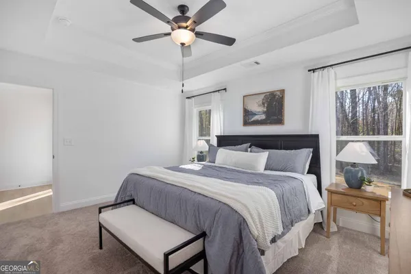 a bedroom with a bed and a lamp on dresser