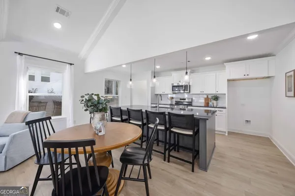 a kitchen with a dining table chairs and refrigerator