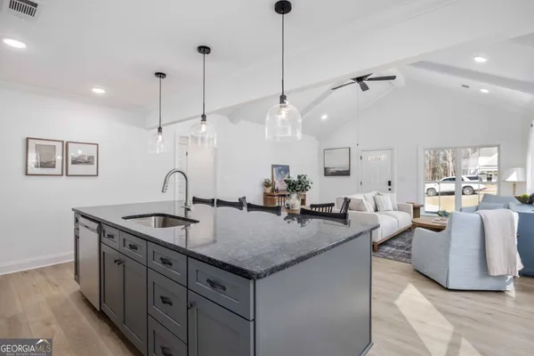 a kitchen with center island a sink stove and wooden floor