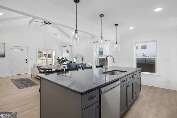 a kitchen with granite countertop a sink and cabinets