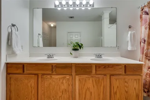 a spacious bathroom with a shower a sink and a mirror
