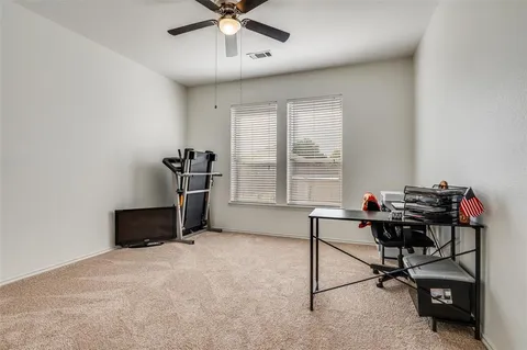 a view of a workspace with furniture and a window