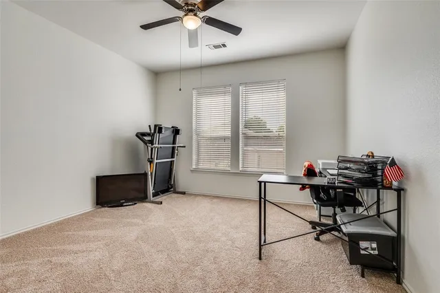 a view of a workspace with furniture and a window