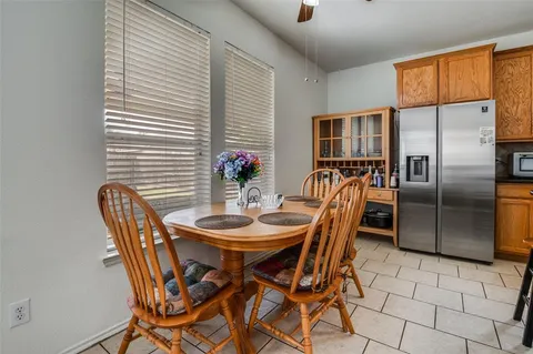 a open dining room with stainless steel appliances kitchen island granite countertop furniture and a large window