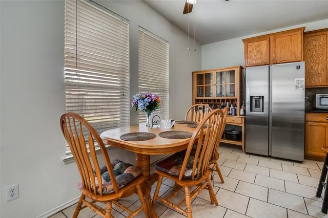 a open dining room with stainless steel appliances kitchen island granite countertop furniture and a large window