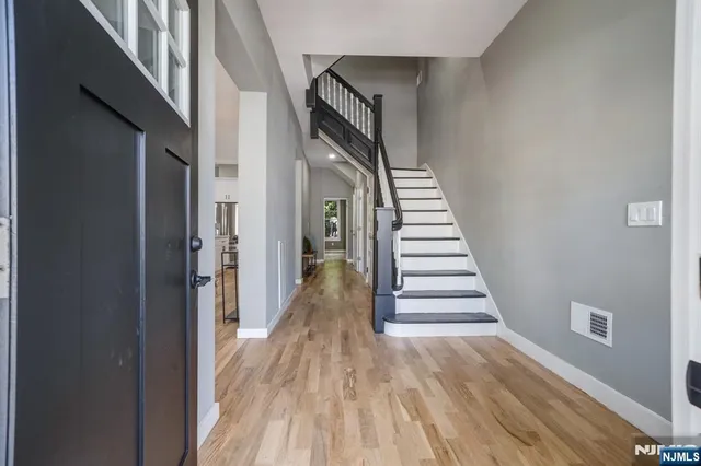 a view of a hallway with wooden floor and entryway