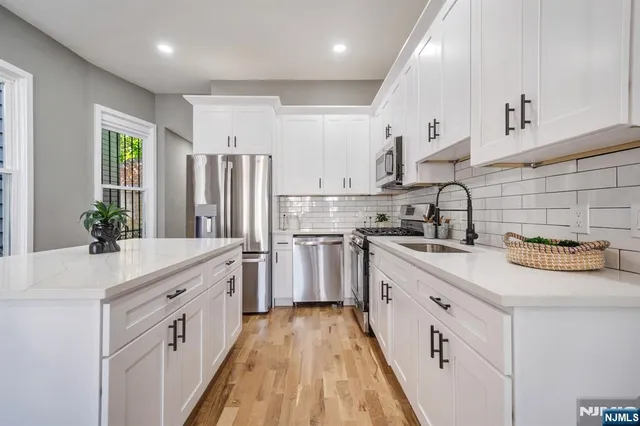 a kitchen with white cabinets and stainless steel appliances