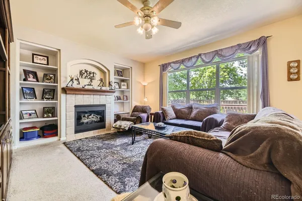 a living room with furniture large window and a fireplace