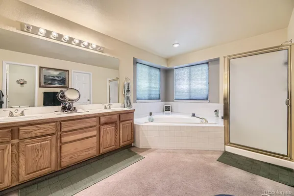 a spacious bathroom with a tub sink and mirror