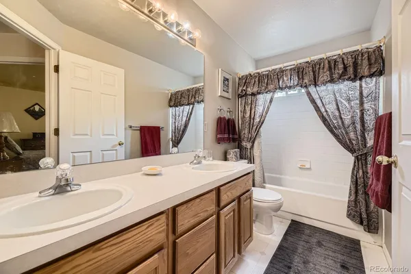 a bathroom with a sink a toilet a mirror and shower