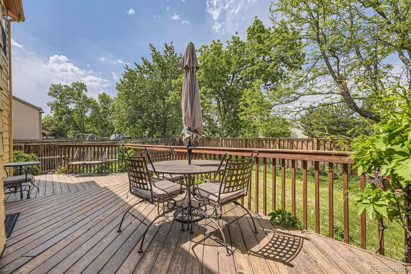 a view of a chair and table on the wooden deck
