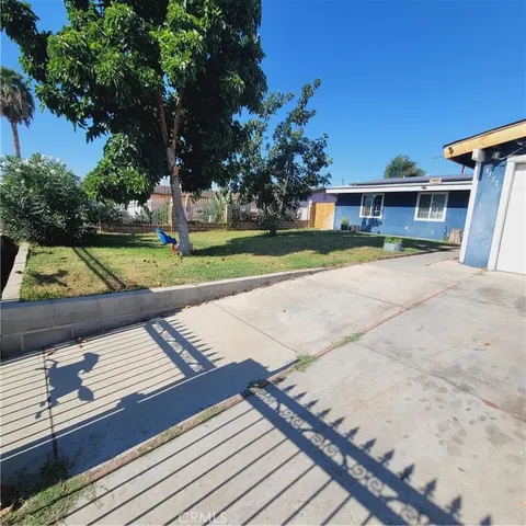 a view of a house with backyard and sitting area
