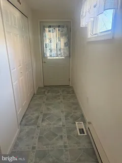 a living room with furniture a rug and kitchen view
