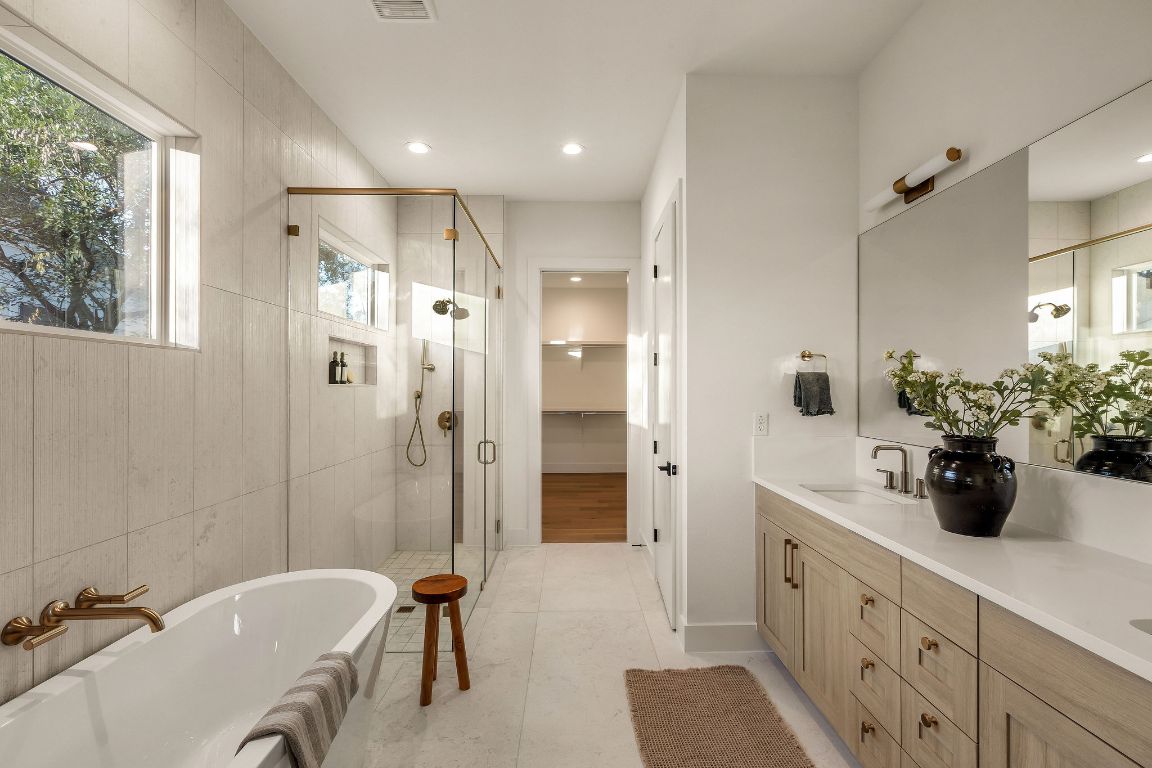 1301 Ruth Avenue Austin, TX 78757 - Photo 8 of 21 Bathroom with a walk in closet, a shower stall, a soaking tub, double vanity, and recessed lighting