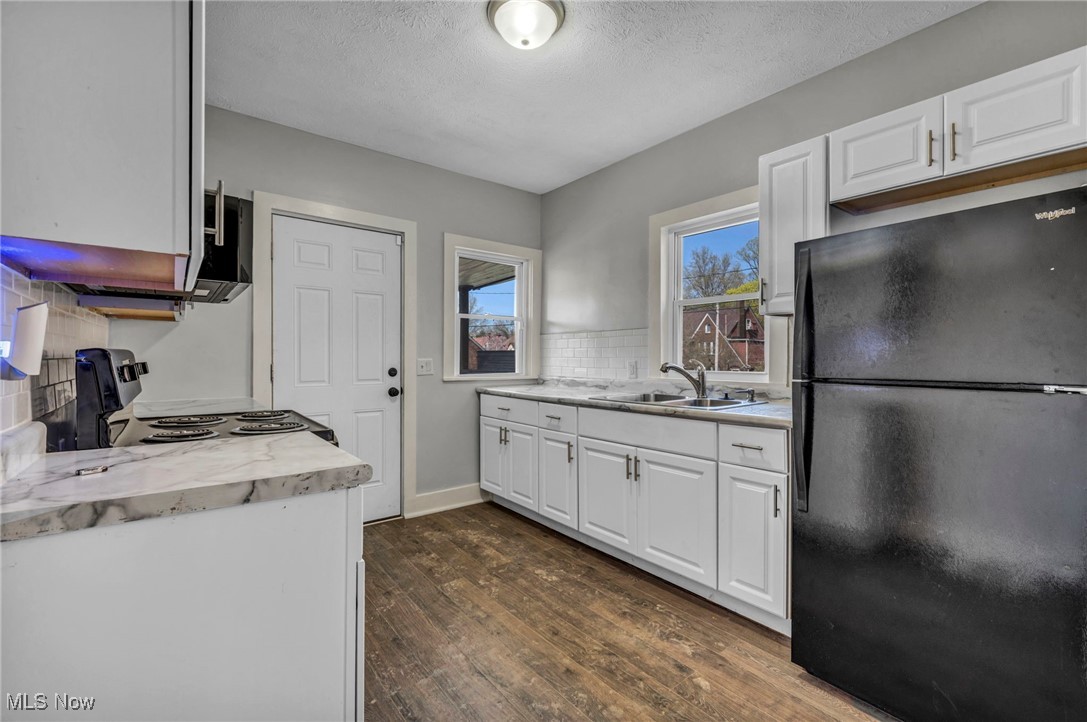 3239 Sycamore Road Cleveland, OH 44118 - Photo 25 of 49 Kitchen with freestanding refrigerator, dark wood-style flooring, a sink, backsplash, and range with electric cooktop