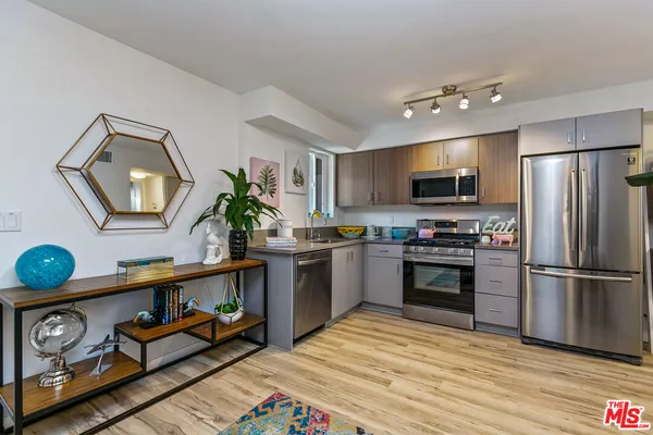 a kitchen with granite countertop a refrigerator stove and microwave