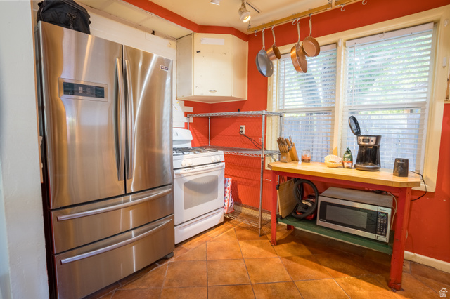 186 West Center Street Moab, UT 84532 - Photo 5 of 15 Kitchen featuring stainless steel French door refrigerator, white gas range, and two windows with blinds
