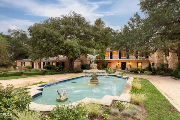 front view of a house with a yard and potted plants