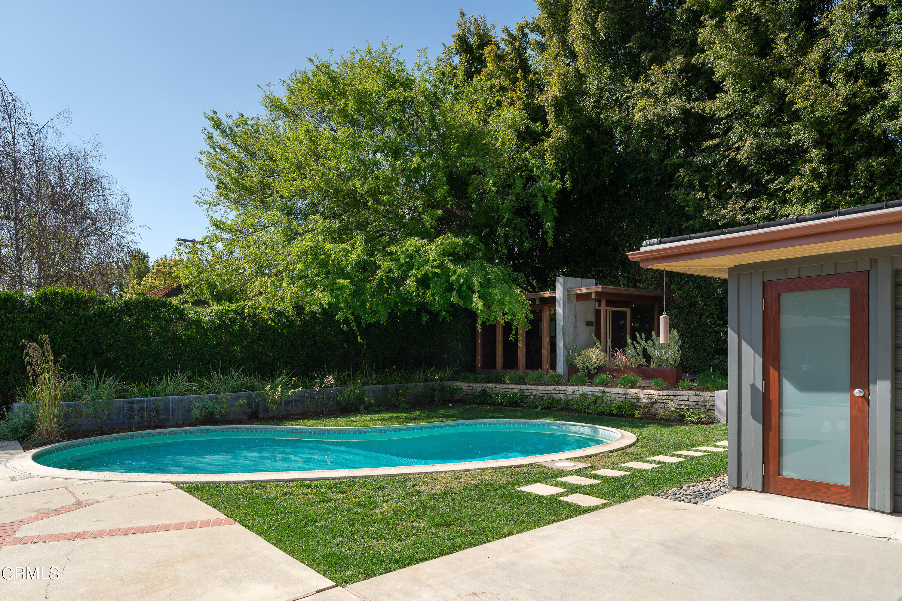 1025 Nithsdale Road Pasadena, CA 91105 - Photo 53 of 73 a view of a white house next to a yard with big trees