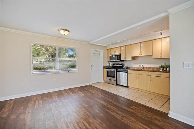 a kitchen with granite countertop white cabinets and stainless steel appliances