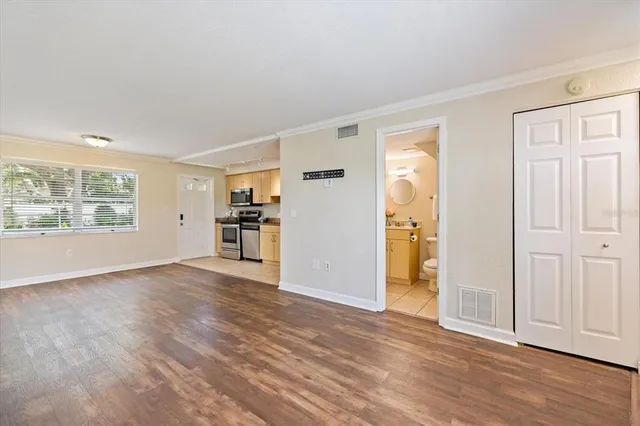 an empty room with wooden floor and windows