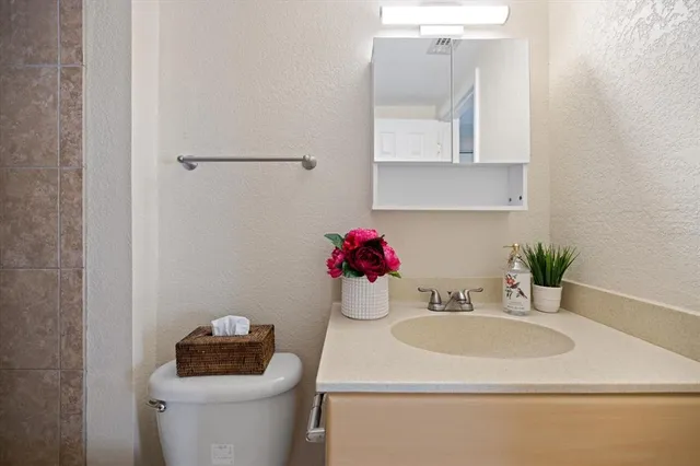 a bathroom with a sink toilet and a mirror