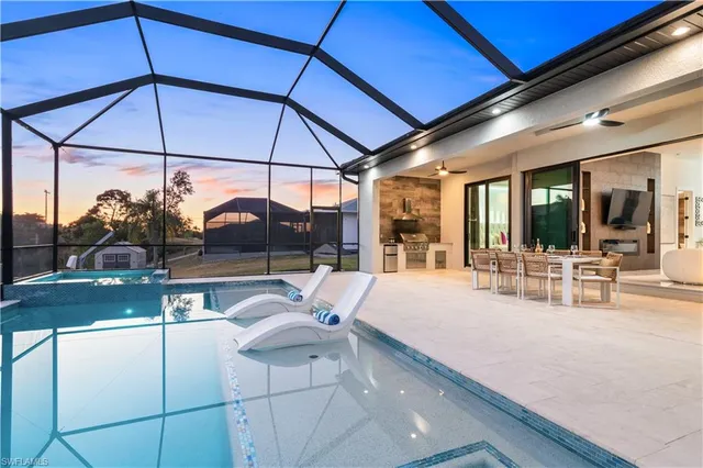 a view of a patio with dining table and chairs under an umbrella