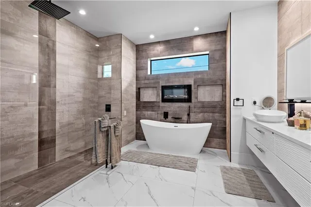 a bathroom with a white tub shower and mirror