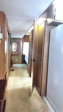a view of a hallway with wooden cabinets