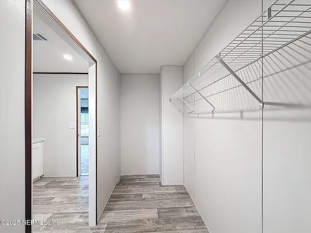 a view of a hallway with wooden floor and entryway
