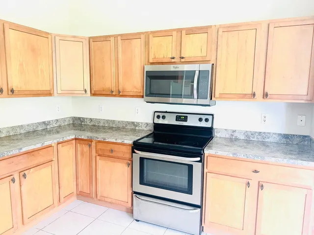 a kitchen with granite countertop white cabinets and stainless steel appliances