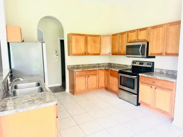 a kitchen with stainless steel appliances granite countertop a stove top oven a sink and dishwasher