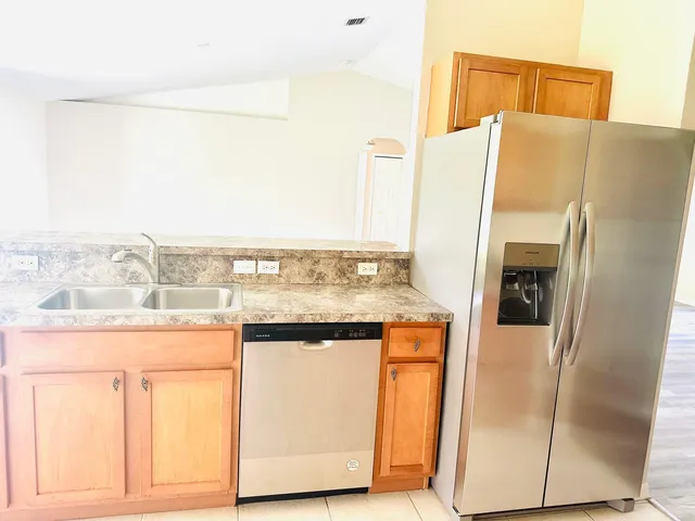 a kitchen with stainless steel appliances granite countertop a refrigerator and a stove
