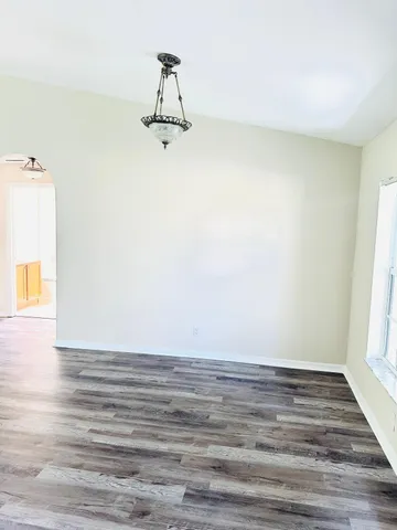 a view of a room with wooden floor and windows
