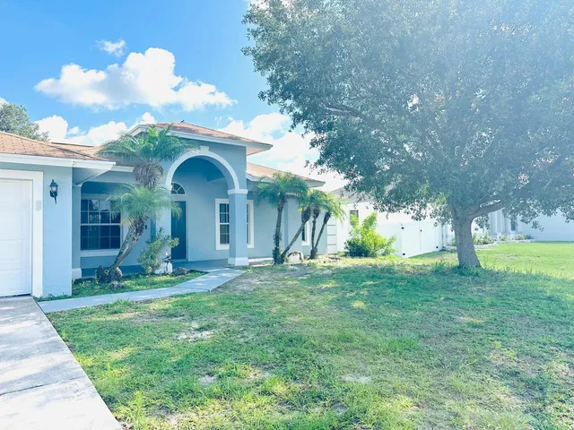 a view of a house with garden and trees