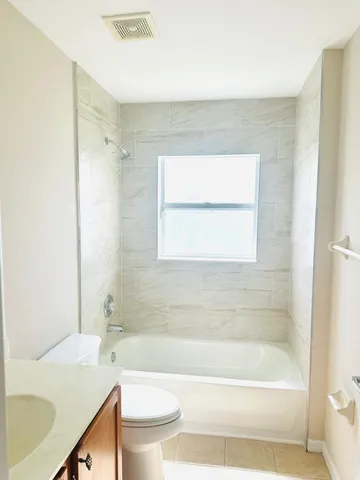 a bathroom with a bathtub shower sink vanity and a toilet