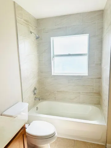 a bathroom with a bathtub shower and a toilet