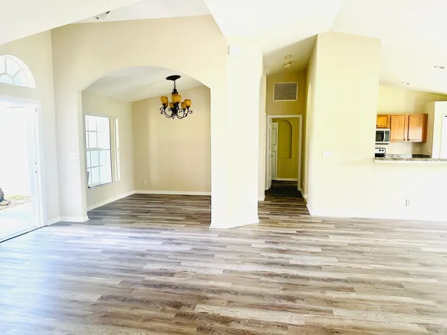 a view of a hallway with wooden floor and a bathroom