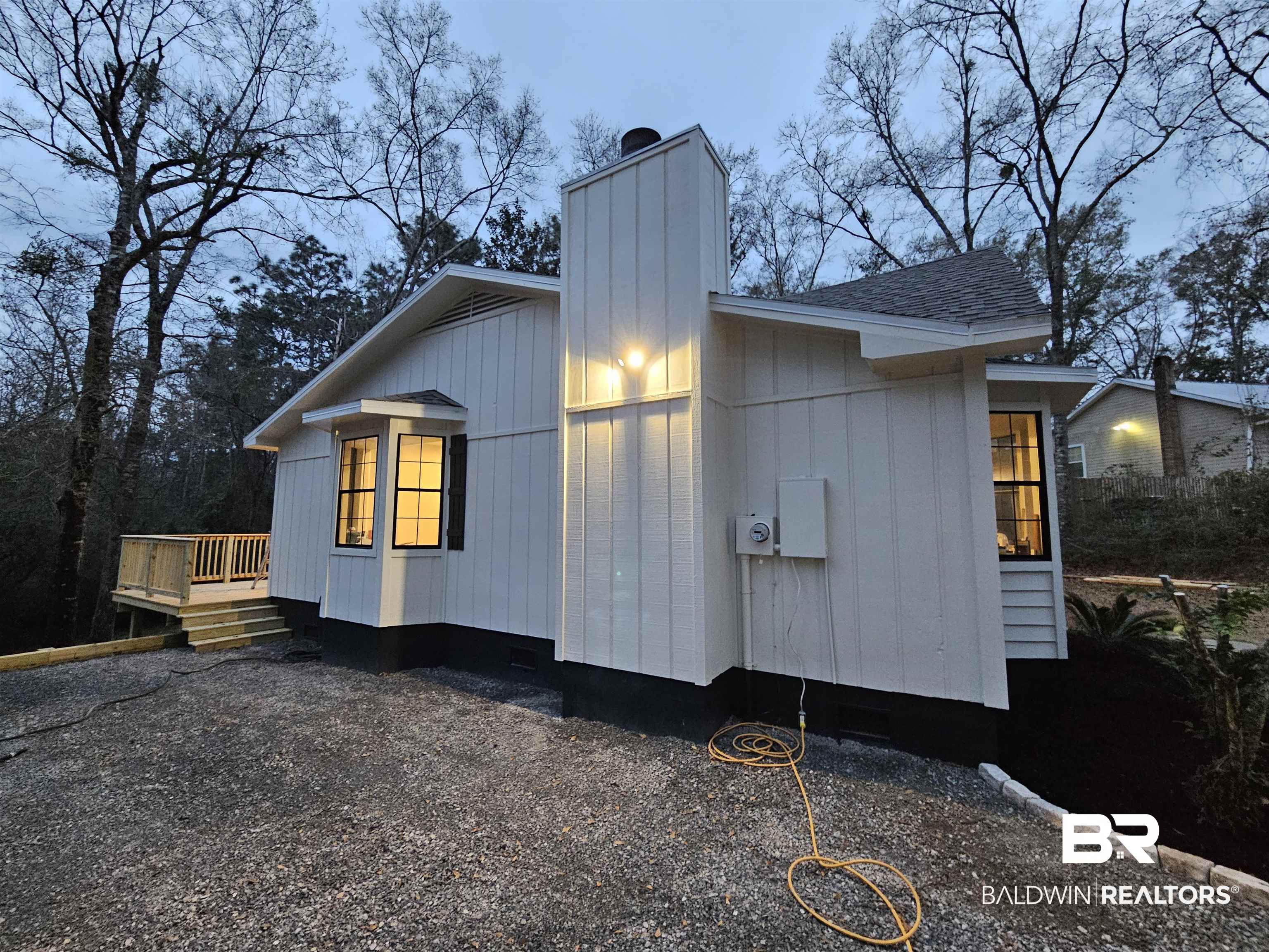 138 Wicker Way Daphne, AL 36526 - Photo 4 of 32 Property exterior at dusk featuring a chimney, a wooden deck, and a shingled roof