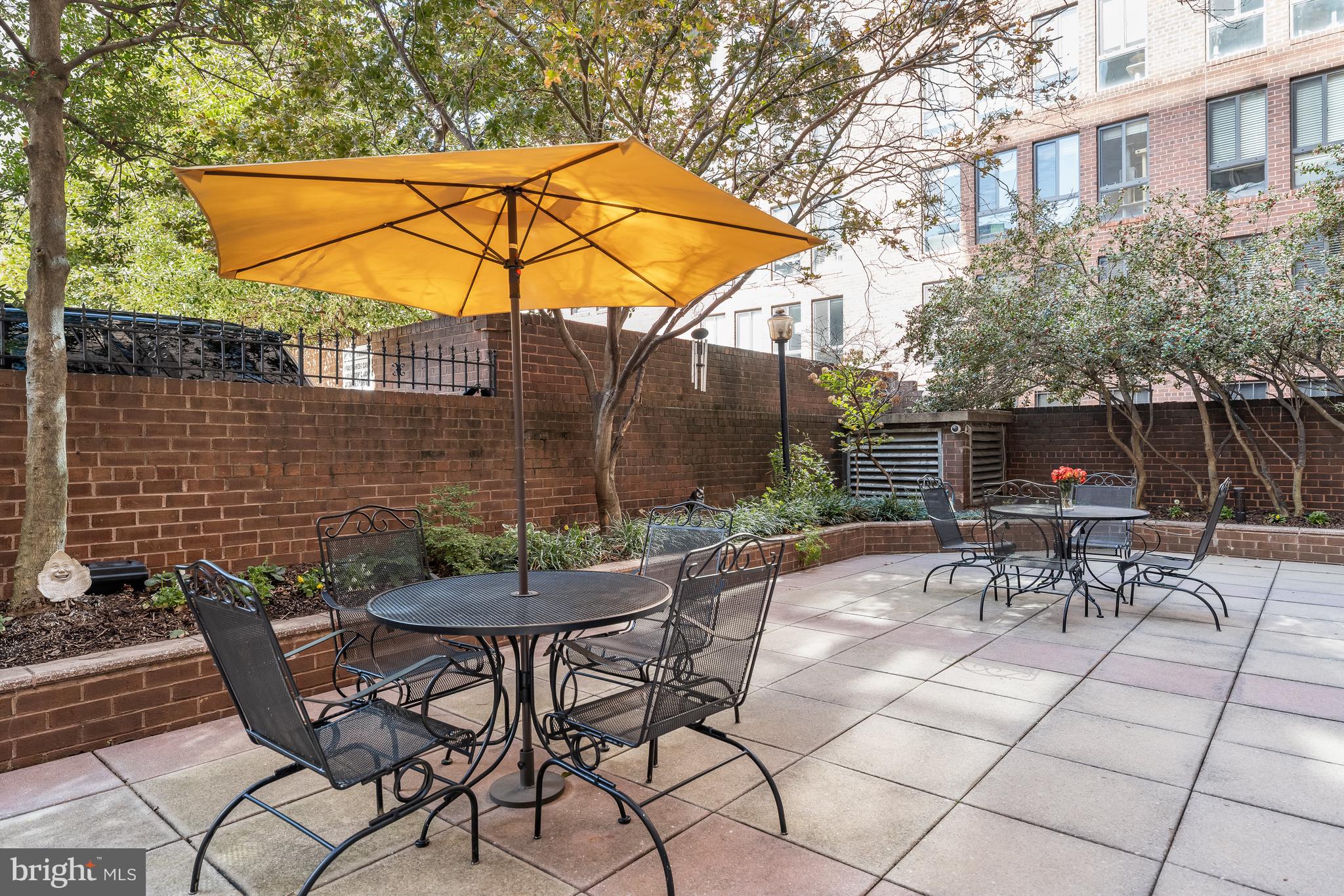 1260 21st Street Northwest, Unit 107 Washington, DC 20036 - Photo 16 of 21 a view of patio with table and chairs and potted plants