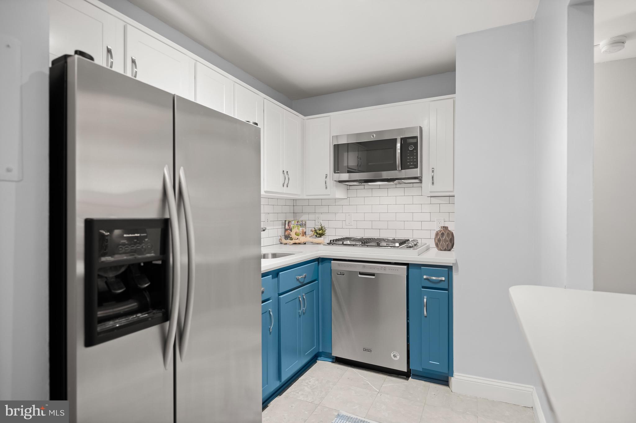 1260 21st Street Northwest, Unit 107 Washington, DC 20036 - Photo 7 of 21 a kitchen with stainless steel appliances a refrigerator sink and microwave