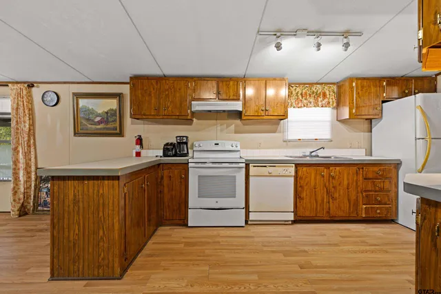a kitchen with granite countertop a sink cabinets stainless steel appliances and a window