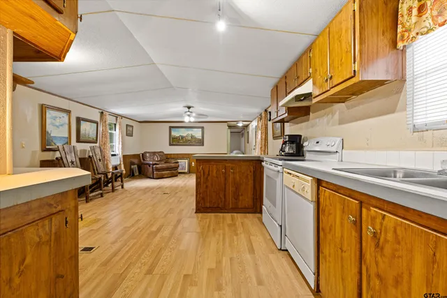 a large kitchen with stainless steel appliances granite countertop a lot of counter space and wooden floors