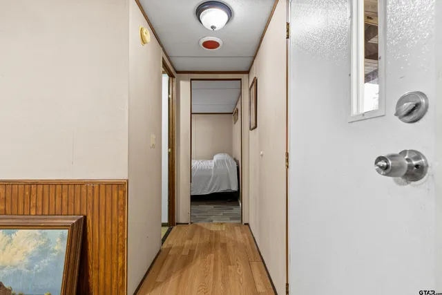 a view of a hallway with wooden floor and a chandelier